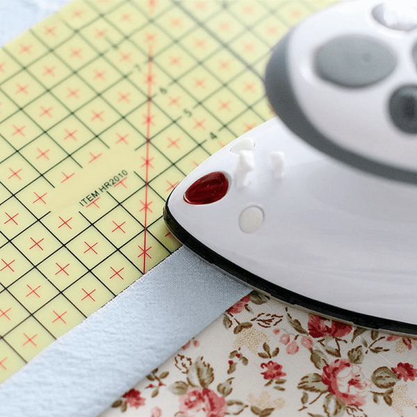 Fabric folded over Hot Ironing Ruler, demonstrating easy hem measurement and pressing