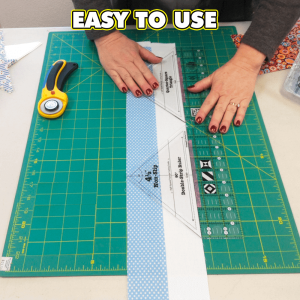 Hands using the 90 Degree Double-Strip Quilt Ruler to accurately cut fabric triangles