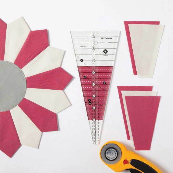 Quilter cutting 1-inch to 8-inch shapes from fabric strips using the Dresden Plate Template Ruler for precision quilting