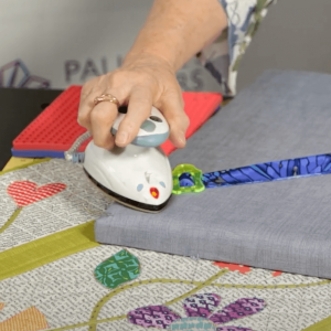 Rolly Sasher Tool in action, creating evenly folded quilt binding for sewing
